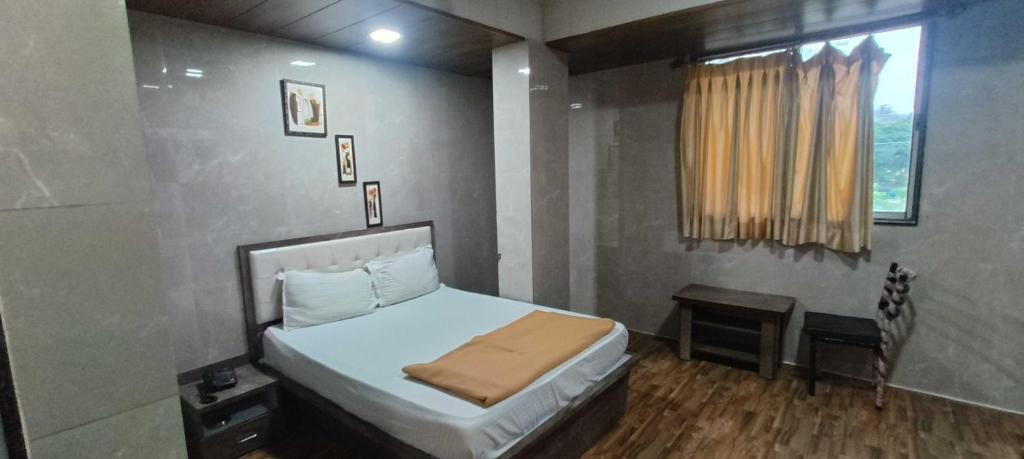 a small bedroom with a bed and a window at Hotel O Kumar's Amantran Lodging in Manor