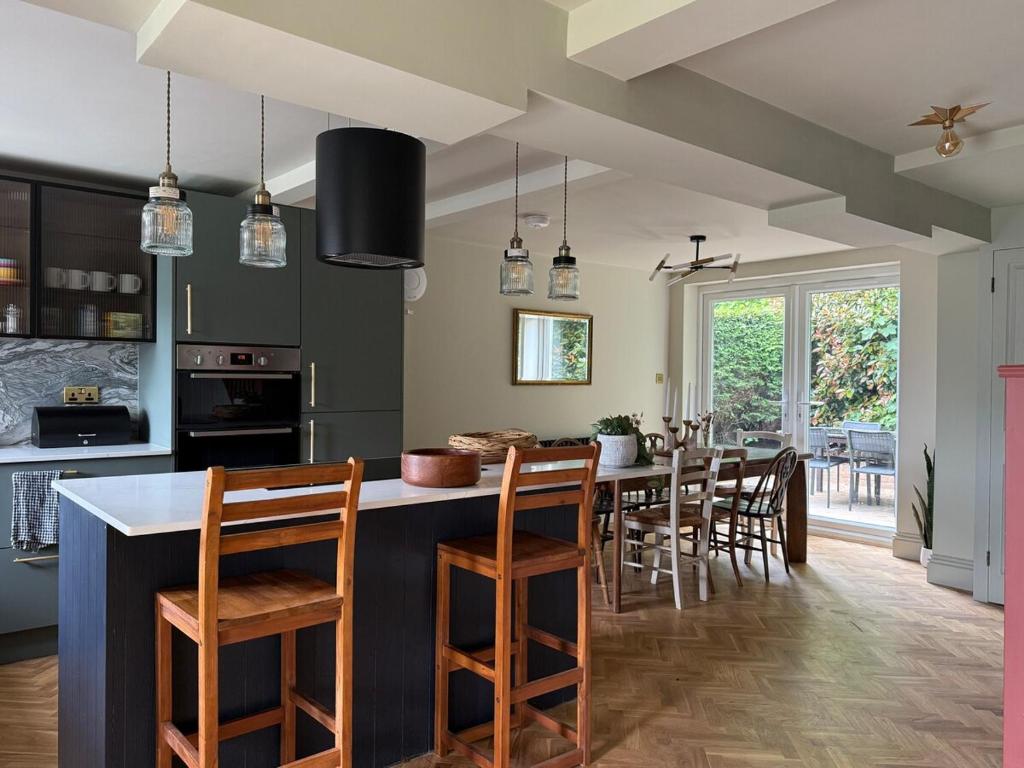 una cucina con una grande isola con sedie e un tavolo di Spacious Forest Row Home by Ashdown Trails a Forest Row