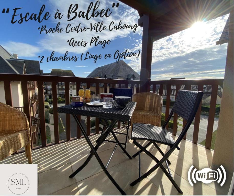 a black table and chairs on a balcony at Escale à Balbec- Proche plage et Centre ville Cabourg in Cabourg