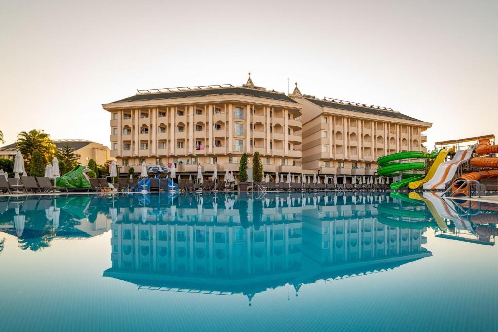 a large building with a pool in front of it at Calimera Hane Garden Hotel in Side