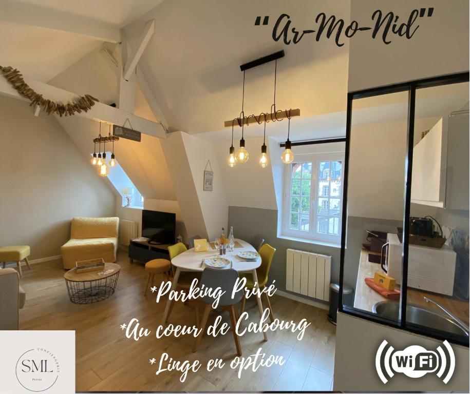 a living room with a table and a kitchen at Armonid au coeur de Cabourg in Cabourg