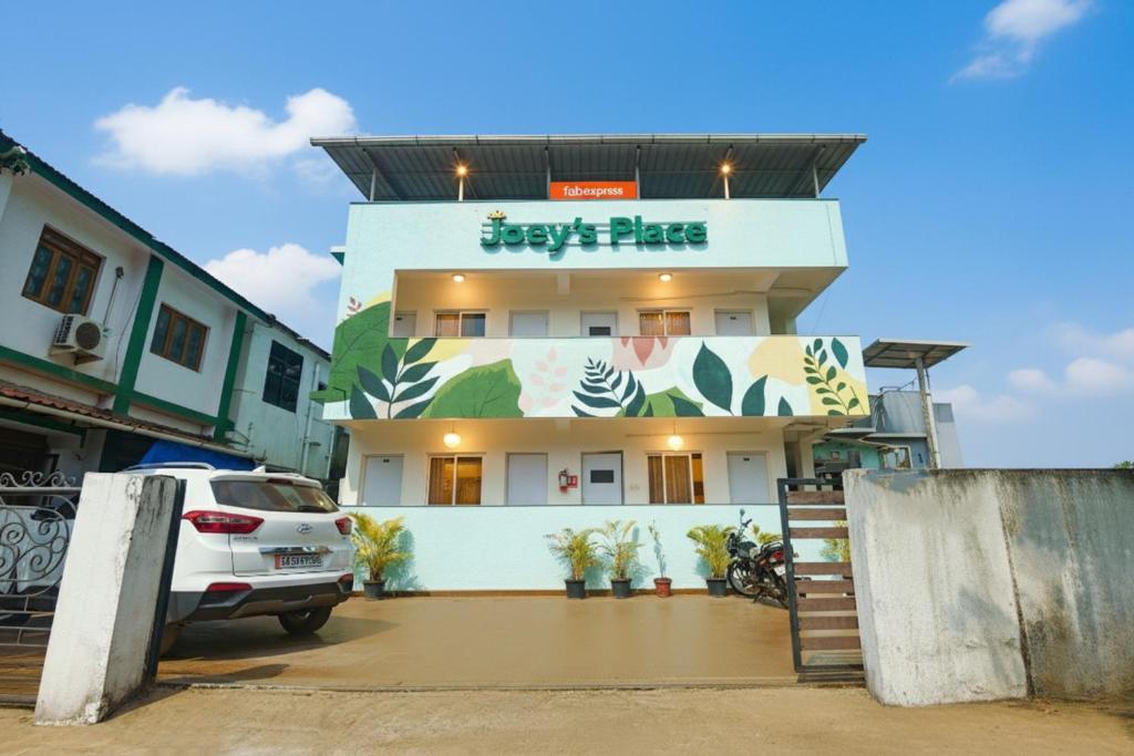 a white car parked in front of a building at Hotel Joey's Place - Nr Panjim in Nerul