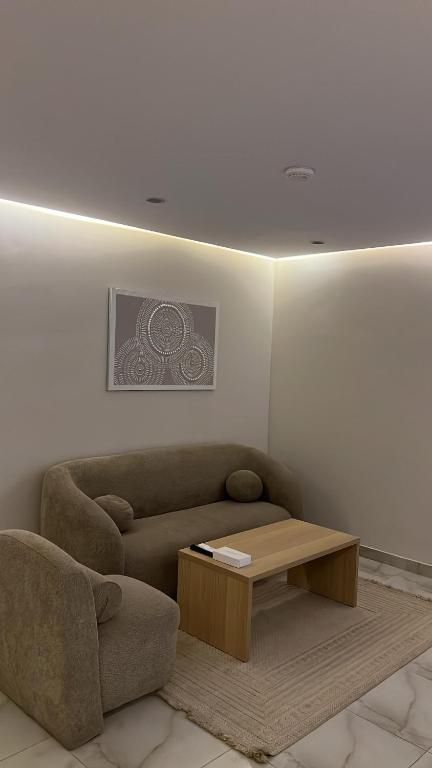 a living room with a couch and a coffee table at شقة بغرفتين نوم وصالة بدخول ذكي in Al Madinah