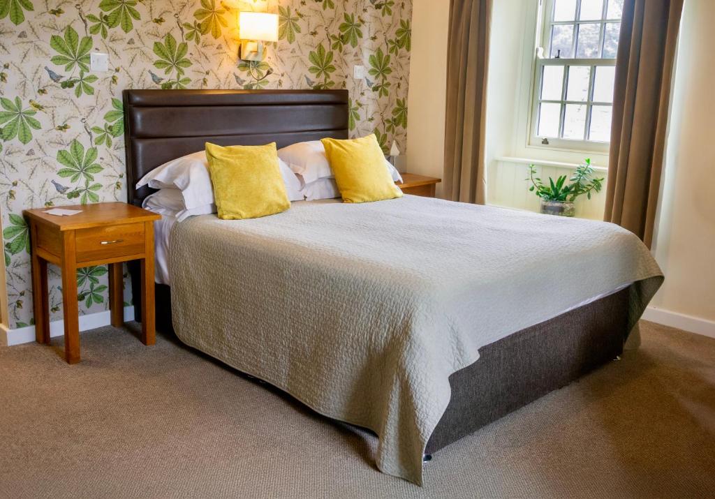 Un dormitorio con una cama grande con almohadas amarillas. en Red Lion Inn, en Newbrough