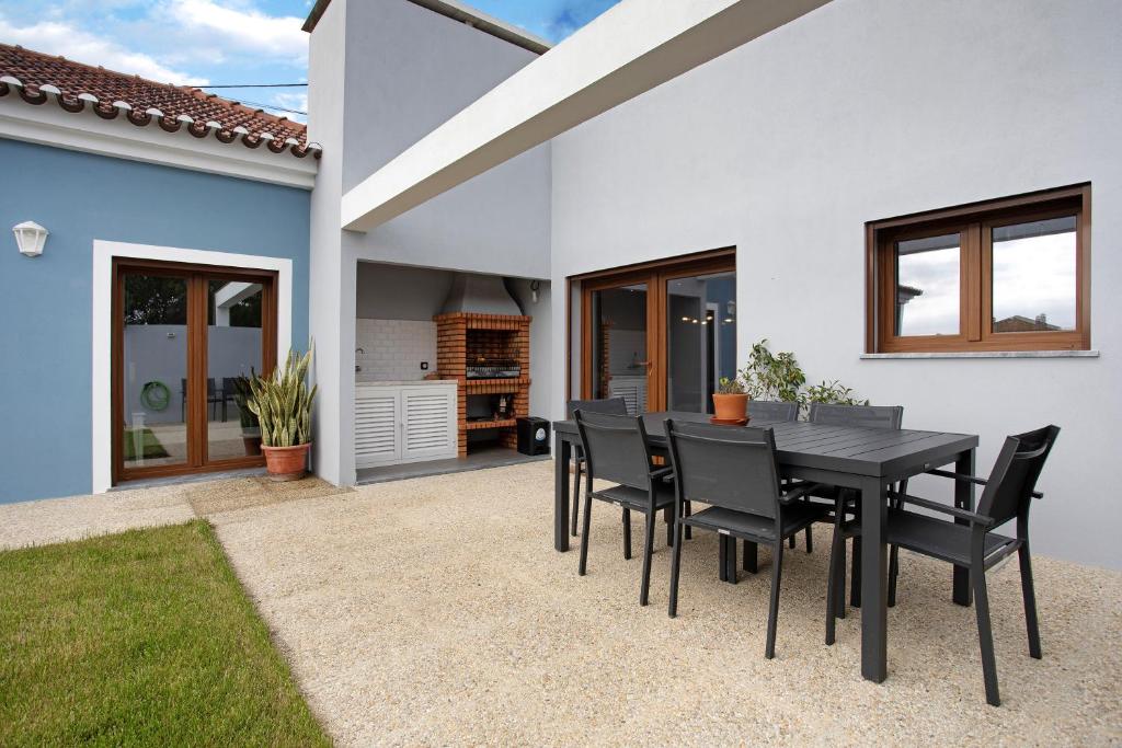a black dining table and chairs in a house at Casa d'Avó em Santa Bárbara in Casa Nova