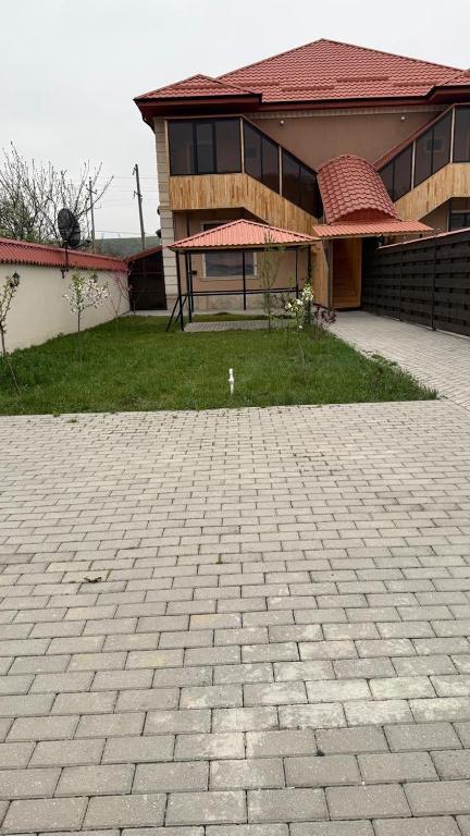 a house with a brick driveway in front of a building at Moy goust house in Qusar