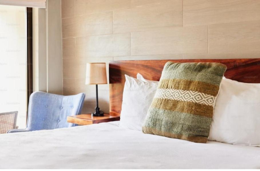 um quarto com uma cama branca e uma almofada em Casa Tirthan Valley em Bashist