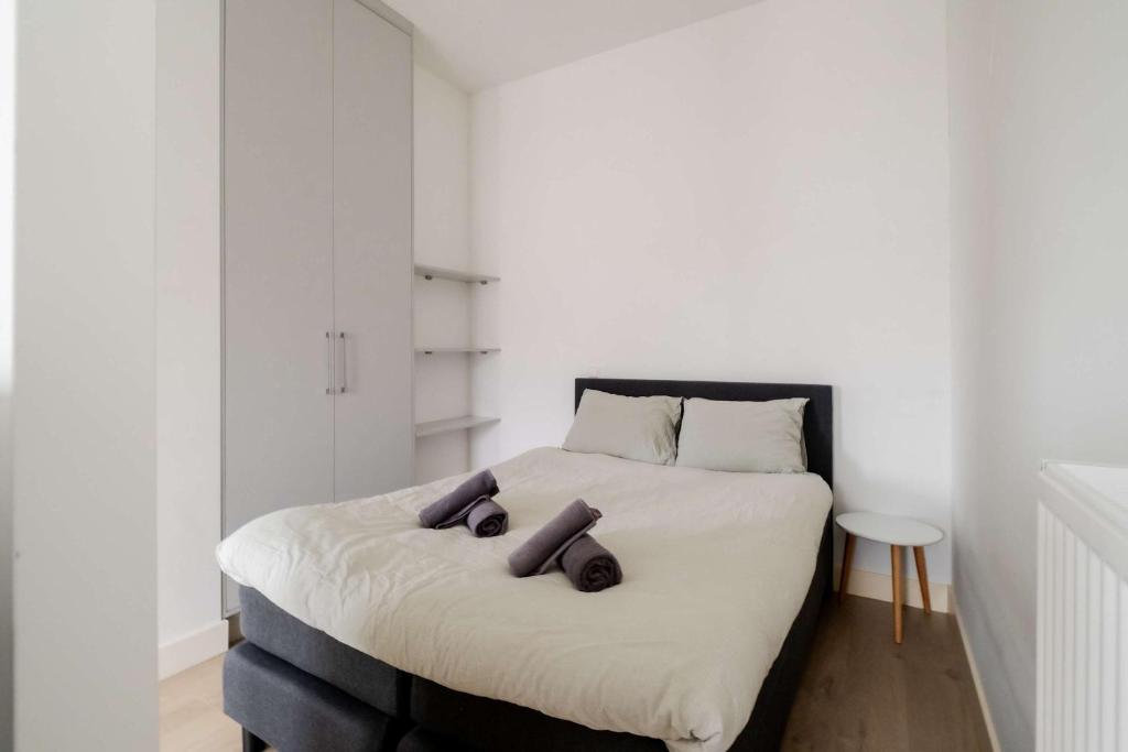 a bedroom with a bed with two pillows on it at Cosy City Apartment in Rotterdam West in Rotterdam