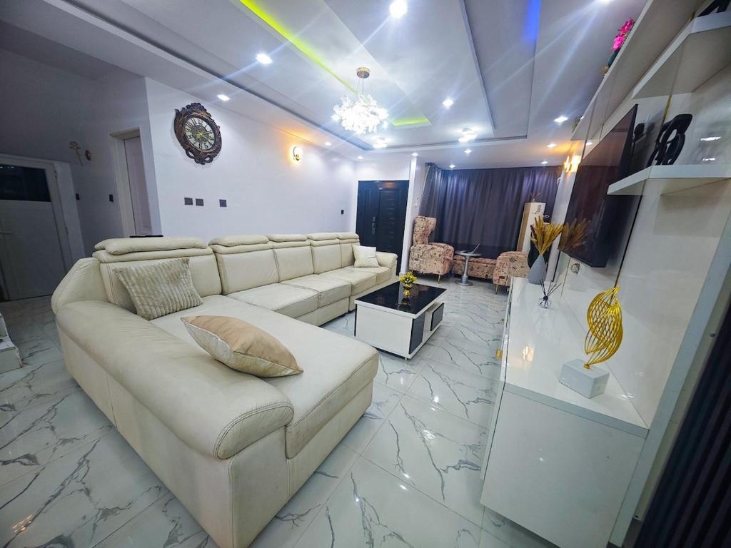 a living room with a white couch and a table at Well Furnished 4 bedrooms duplex available! in Lekki
