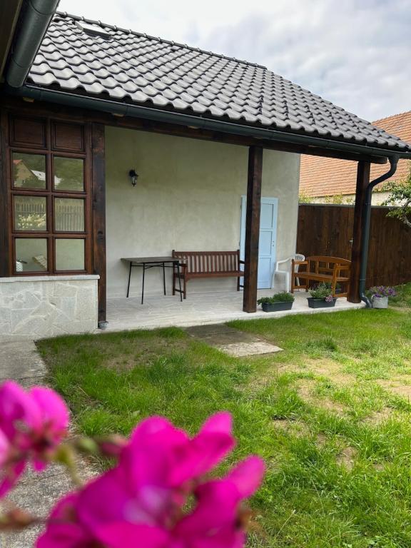 un patio avec un banc et une table avec des fleurs roses dans l'établissement Chalupa na konci světa Světlá, à Studená