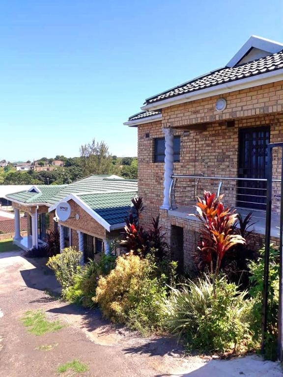 a brick house with a balcony on the side of it at The Amazing Amazon Guesthouse in KwaMakhutha
