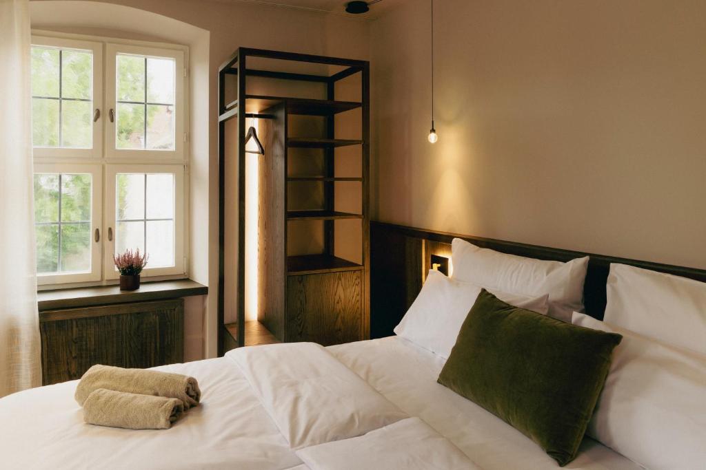 a bedroom with a white bed with a book shelf at HOY bamberg boutique hotel in Bamberg