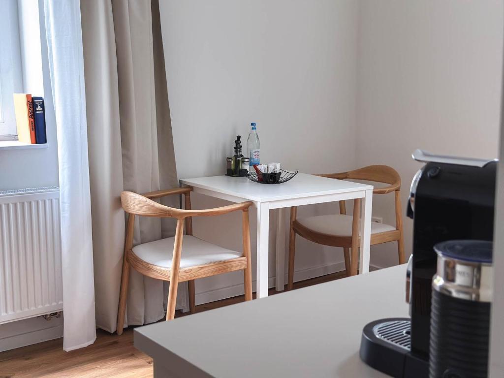 einen kleinen weißen Tisch und Stühle in einem Zimmer in der Unterkunft Stilvolle Suite in Celle - Frühstück, Kaffee, kostenloser Parkplatz und Wohnküche in Celle