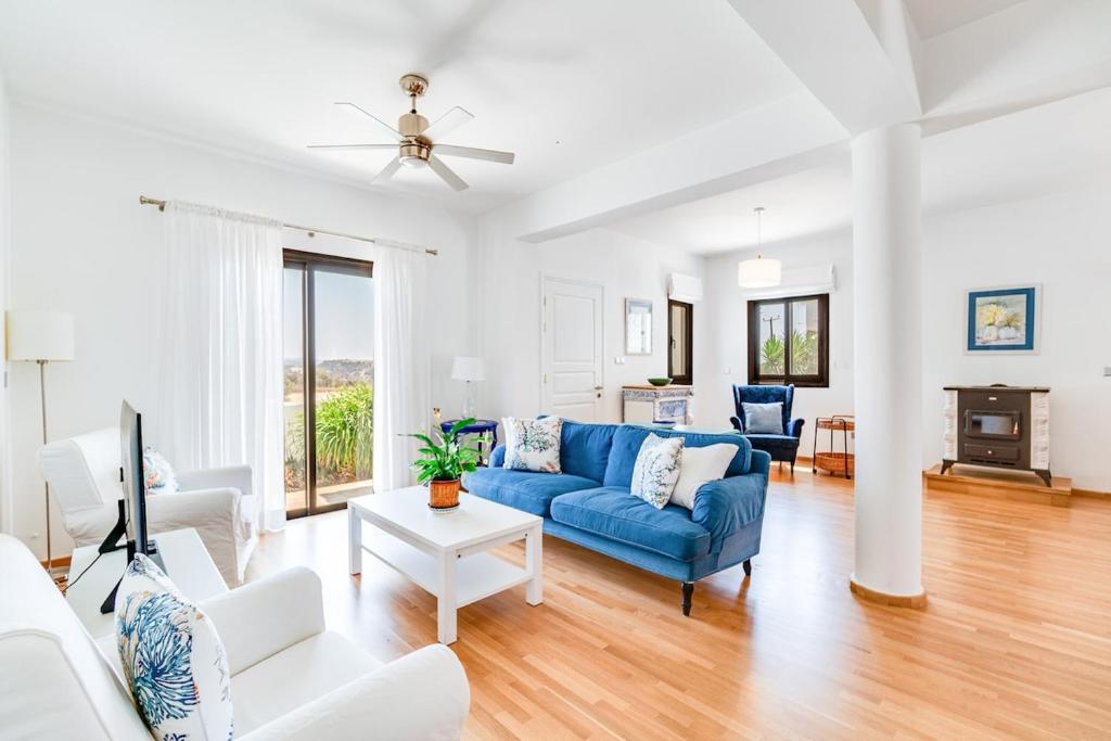 a living room with a blue couch and white furniture at 4 Bedroom Villa With Private Pool in Maroni