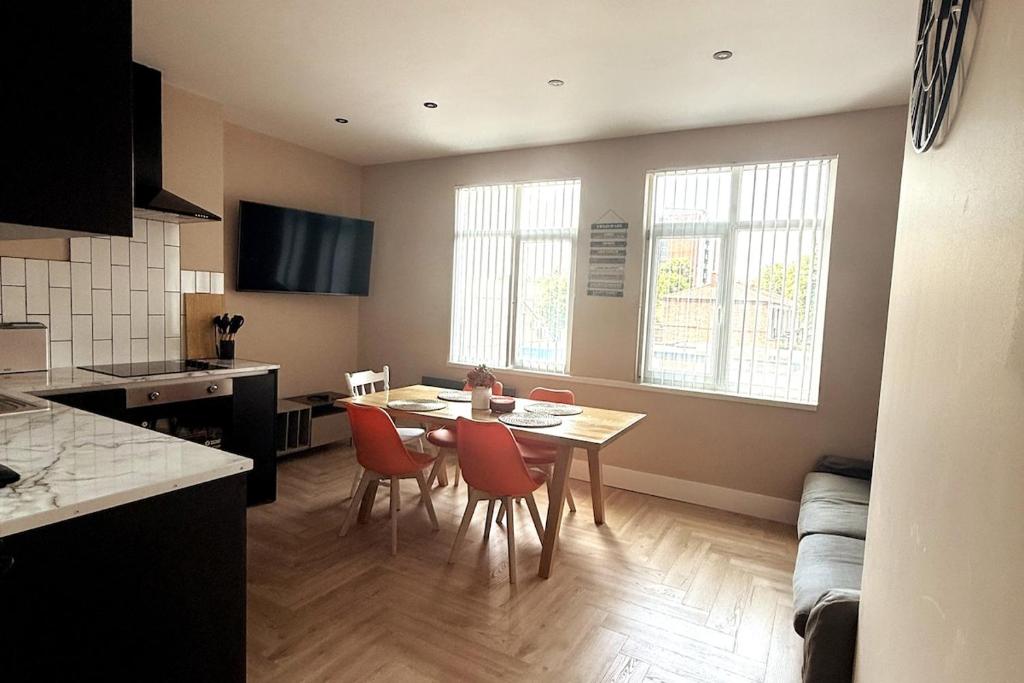 a kitchen and dining room with a table and chairs at Stylish and Bright 2 Bedroom Flat Free Parking in Wallasey