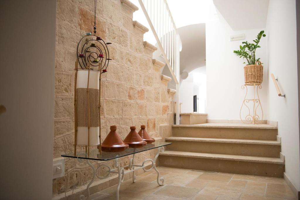 a hallway with stairs and vases on a glass table at Palazzo Indelli in Monopoli