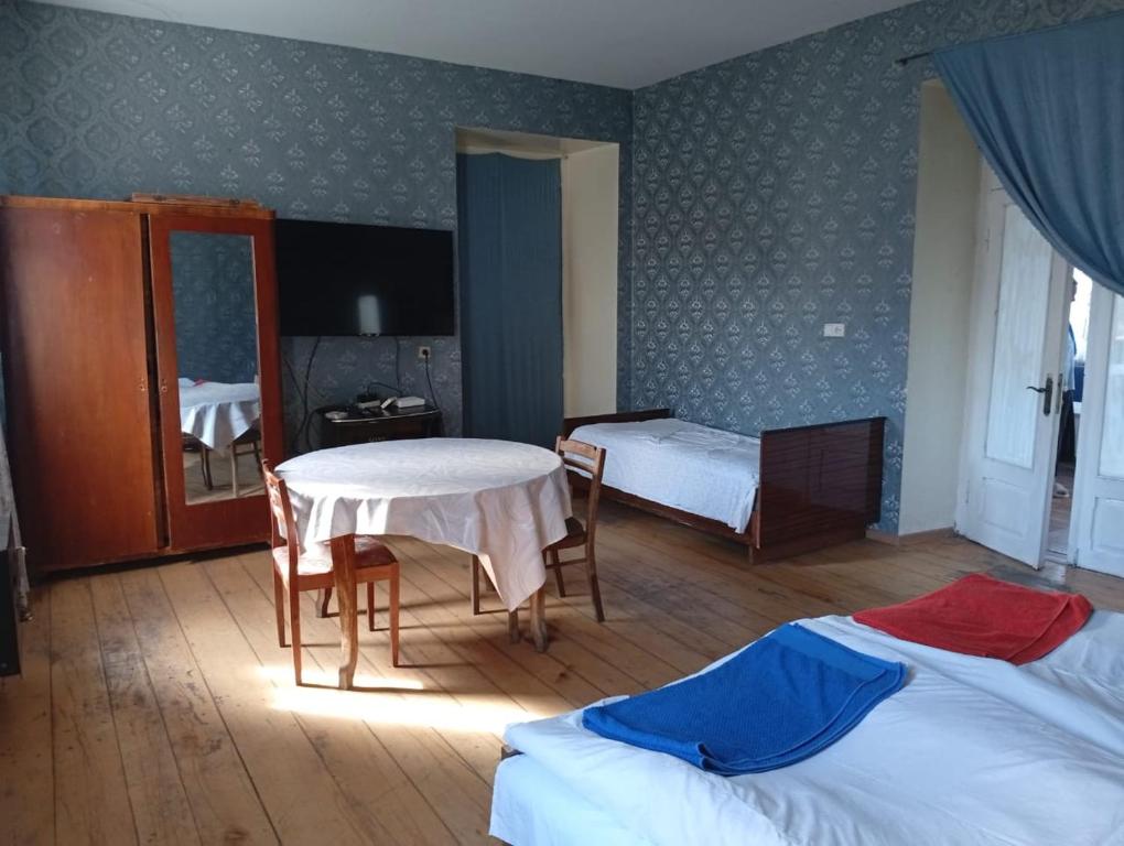 Un dormitorio con dos camas y una mesa y sillas. en Guest House -Lorenzo-, en Telavi