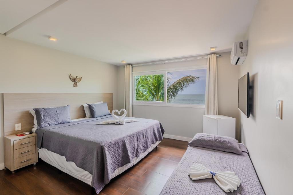 a bedroom with a bed and a large window at Pousada Vila Dos Mares in Morro de São Paulo