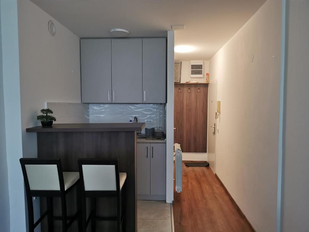 a kitchen with white cabinets and a table and chairs at Andrej 62 in Beograd