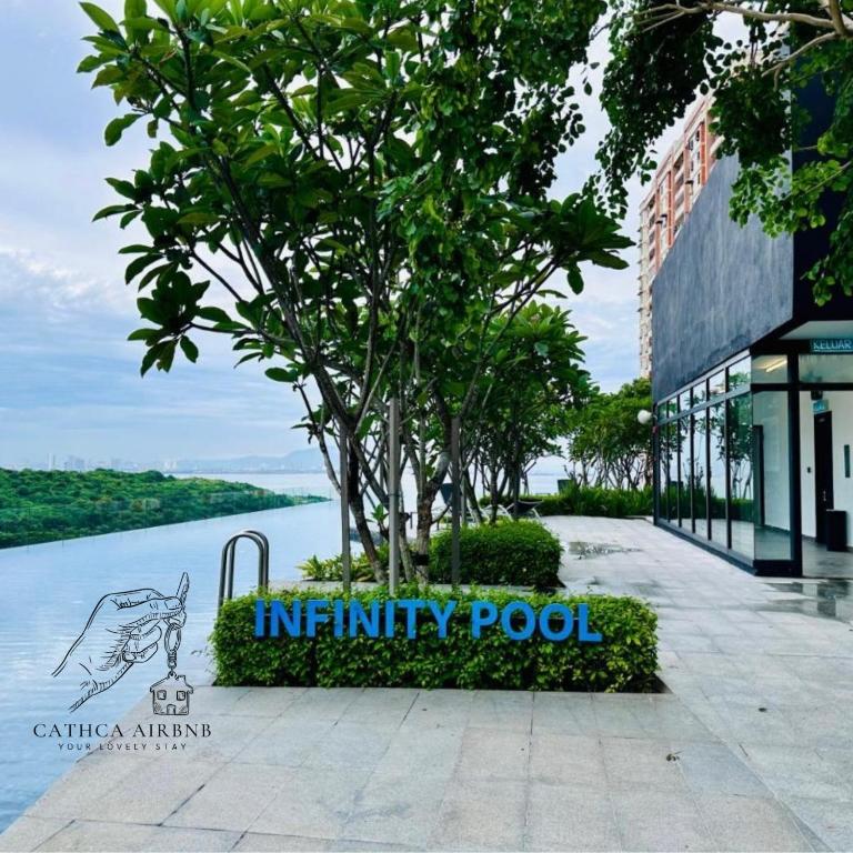 a tree in front of a building next to a body of water at Urban Suites 2BR #SelfCheck-in #6Pax #TopFacilities in Jelutong