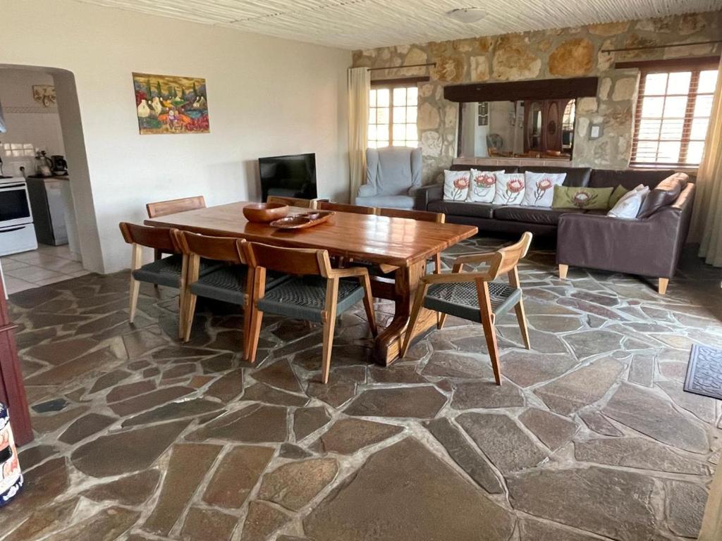a living room with a wooden table and a couch at Klipwerf in Struisbaai