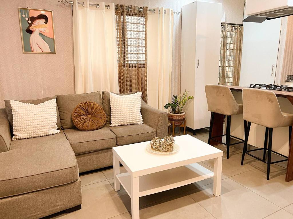 un salon avec un canapé et une table dans l'établissement Colonial leyton apartment, à Sans Souci