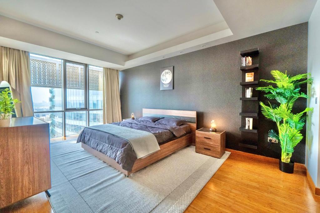 a bedroom with a bed and a large window at Cozy 1BR Apartment Nr World Trade Centre BurJuman in Dubai