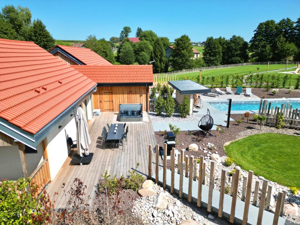 a backyard with a wooden deck and a pool at Le domaine d Isa maison Elor in Vienville