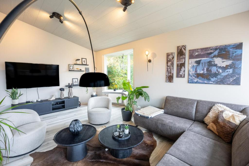 un soggiorno con un divano e una TV di Family-Friendly 5BR Home with Free Parking & Balcony a Reykjavik