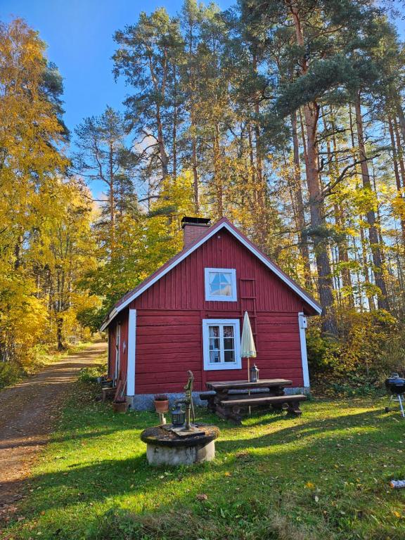 a red cabin in the middle of a forest at Romantic countryside SAUNA Cottage in Maakeski