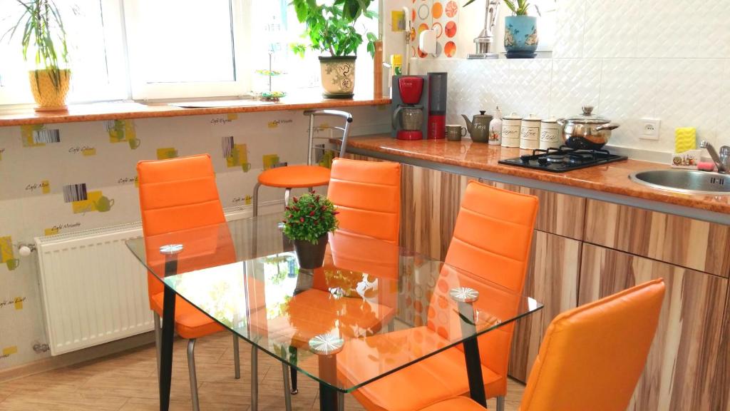 オデッサにあるLuxury apartments in the heartのキッチン(ガラステーブル、オレンジの椅子付)