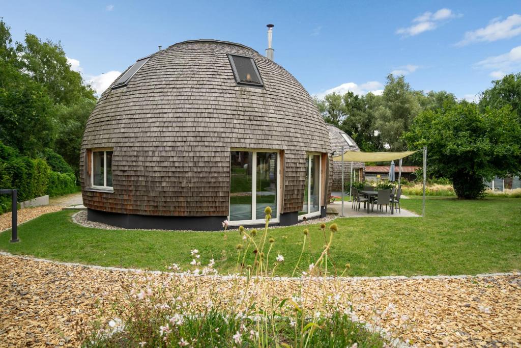a dome house in a garden with a patio at Kugelhaus Eos - Sonnengeküsstes Ferienhaus in organischer Bauweise am Seeufer in Wustrow