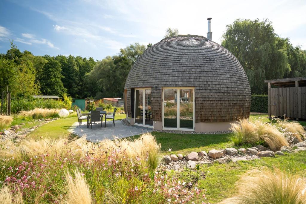 a circular house with a patio in a garden at Kugelhaus Kugellager - Besonderer Rückzugsort in runder Bauweise - reduziert, ruhig und naturnah am Tollensesee in Wustrow