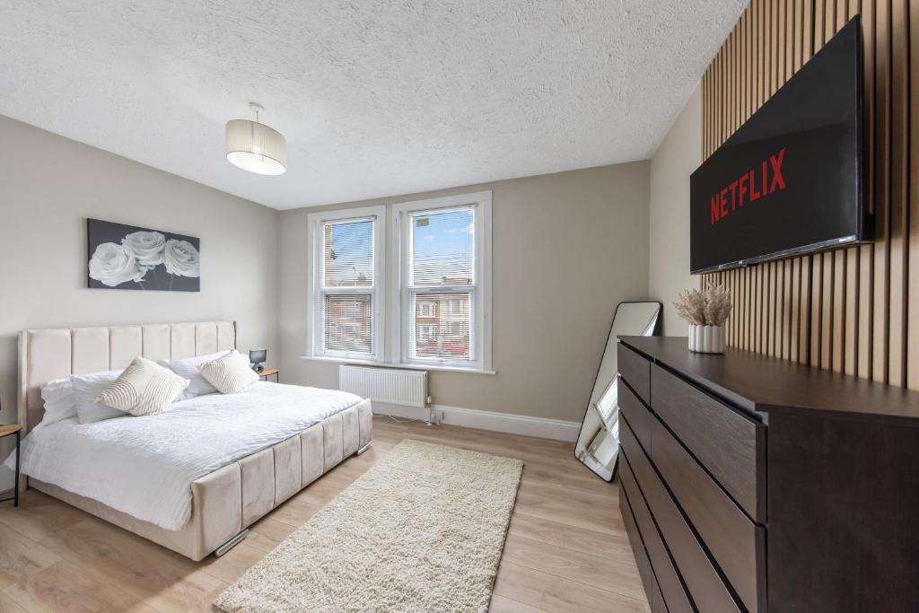a bedroom with a bed and a tv on the wall at modern 4 bdr house rock ave in Gillingham