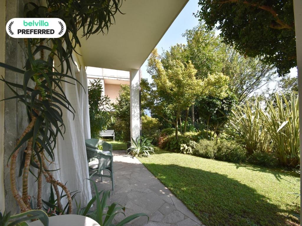 a patio with a lawn with a chair in a yard at Chalet by Lake Maggiore with Garden Views in Verbania