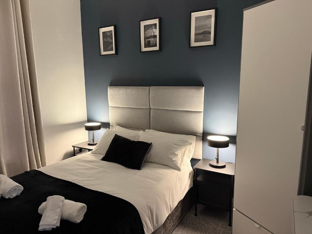 a bedroom with a large bed with two night stands and two lamps at Modern 1 & 2 Bedroom Apartments near Queens University Belfast by MonoStays in Belfast