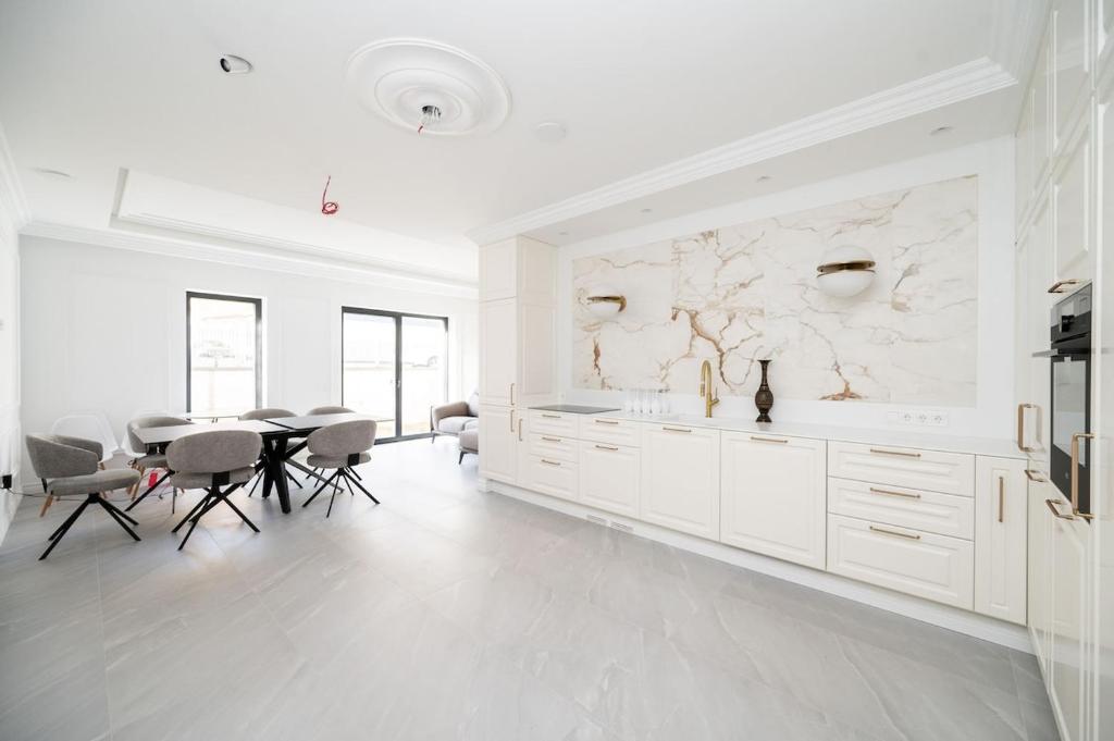 a kitchen with white cabinets and a table and chairs at Vilnius Central House in Vilnius