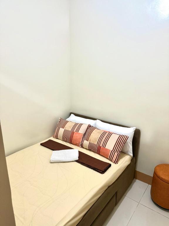 マニラにあるSoléa Suitesのベッド1台(枕2つ付)が備わる小さな客室です。