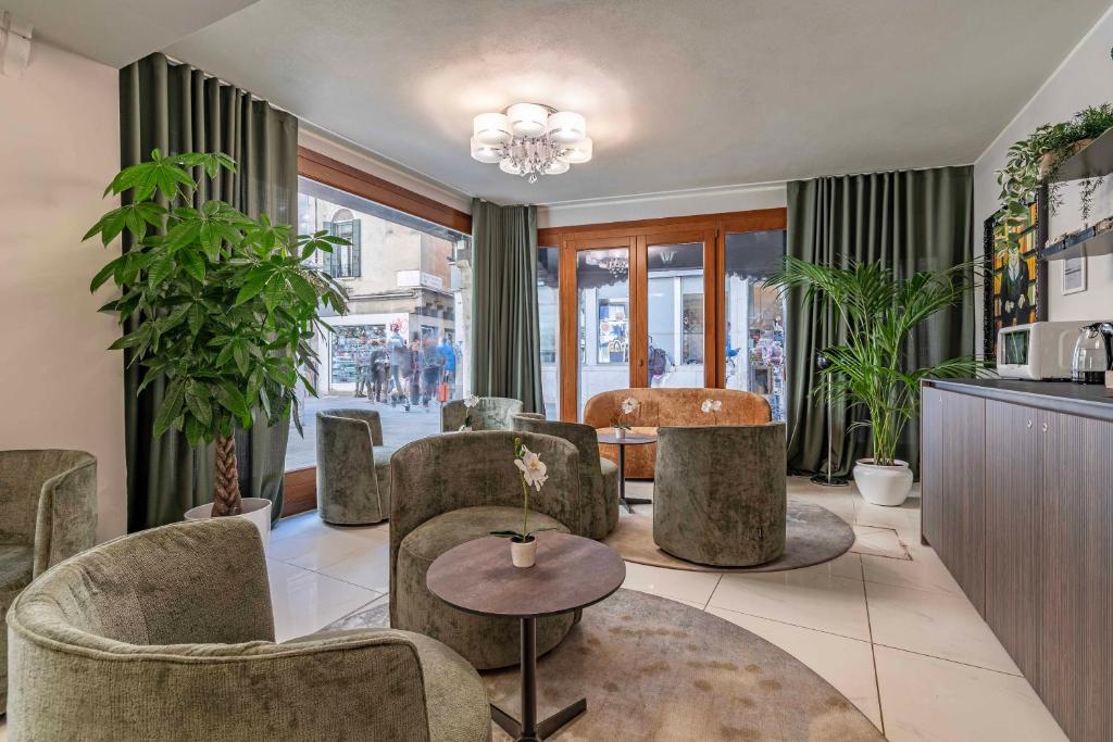 a living room with chairs and a table at Hotel Grifoni in Venice