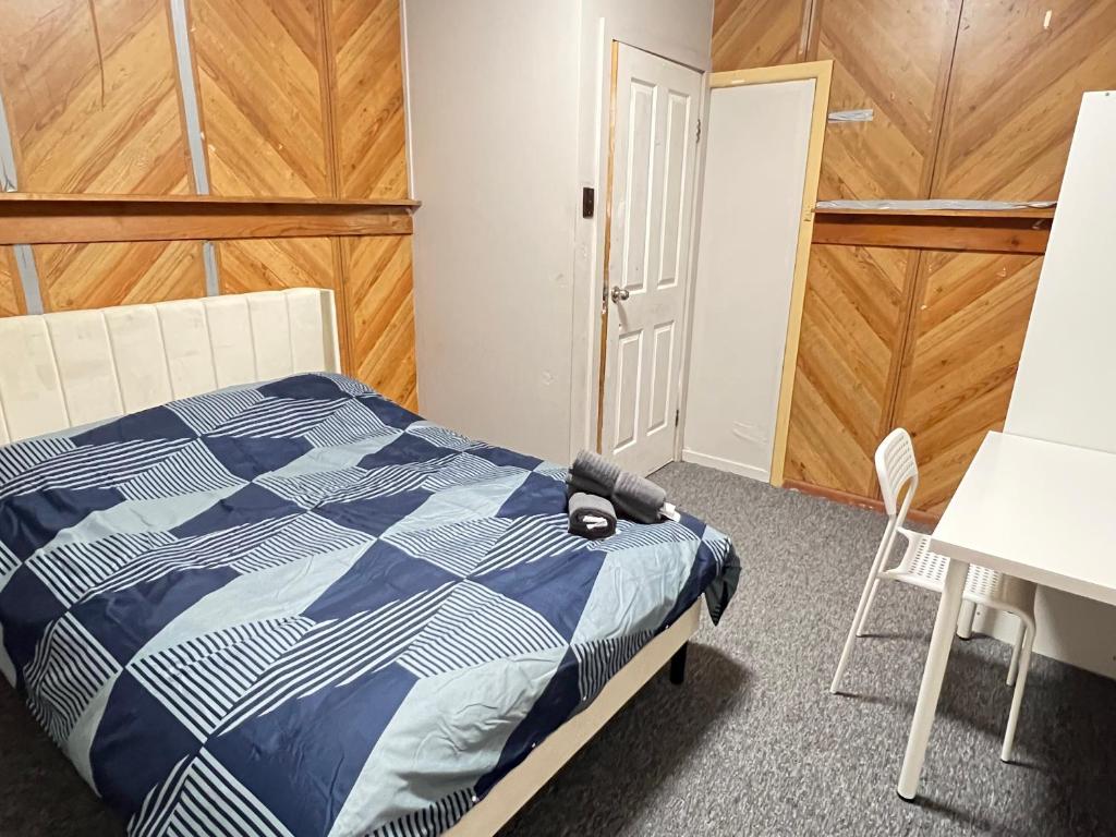 a bedroom with a bed and a table and a chair at Cozy Queen Room Next to Station and Shops - PH6 in Pendle Hills