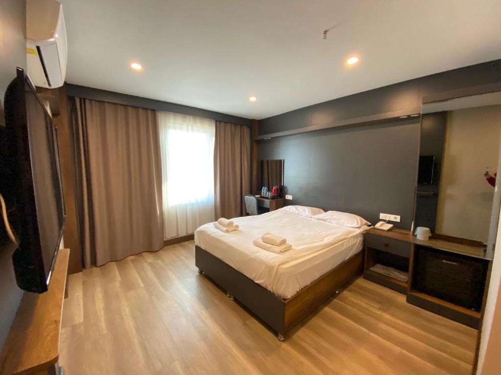 una camera d'albergo con un letto e una televisione di Samsun Airport Resort Hotel a Samsun