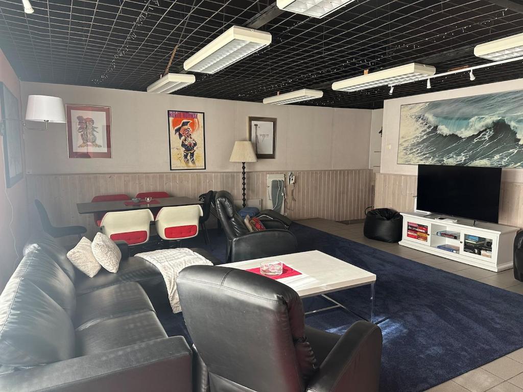 a living room with leather furniture and a flat screen tv at Bytoppen top of the island in Tromsø