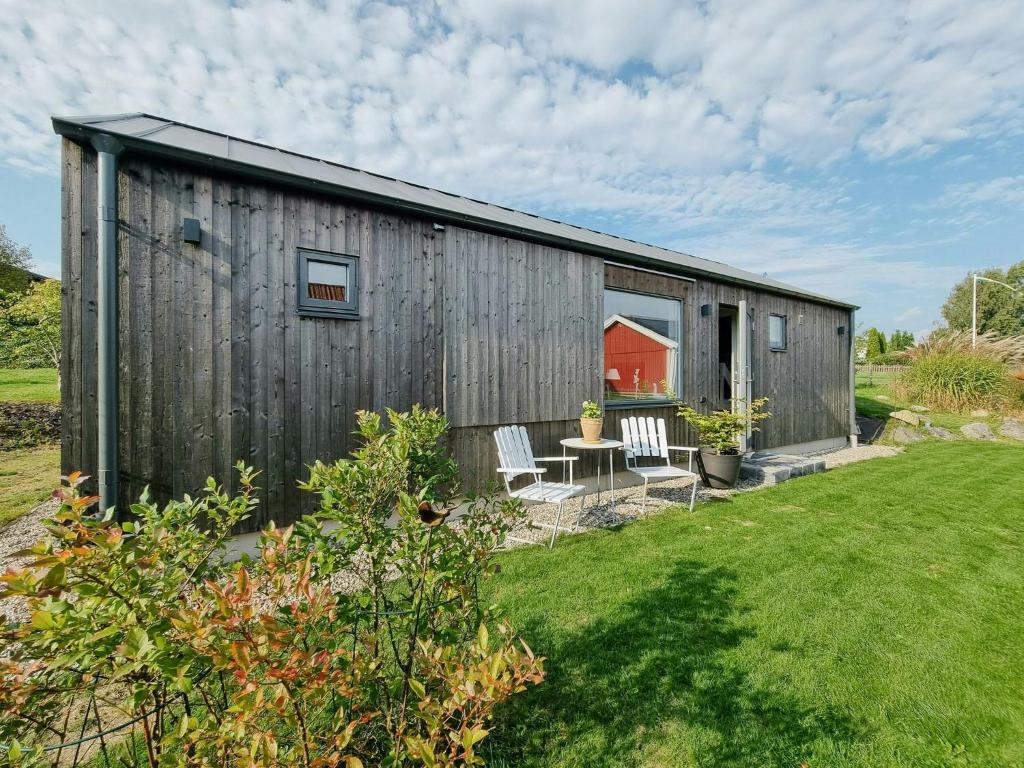 a barn with a table and chairs in a yard at Modern Guest House Near The Sea In Brösarp in Brösarp
