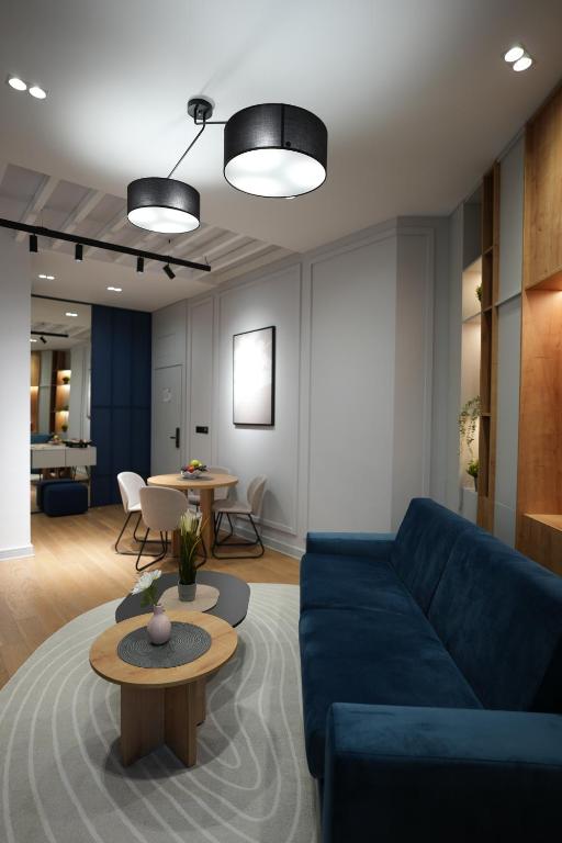 Una sala de estar con un sofá azul y una mesa. en Madera apartments, en Čačak