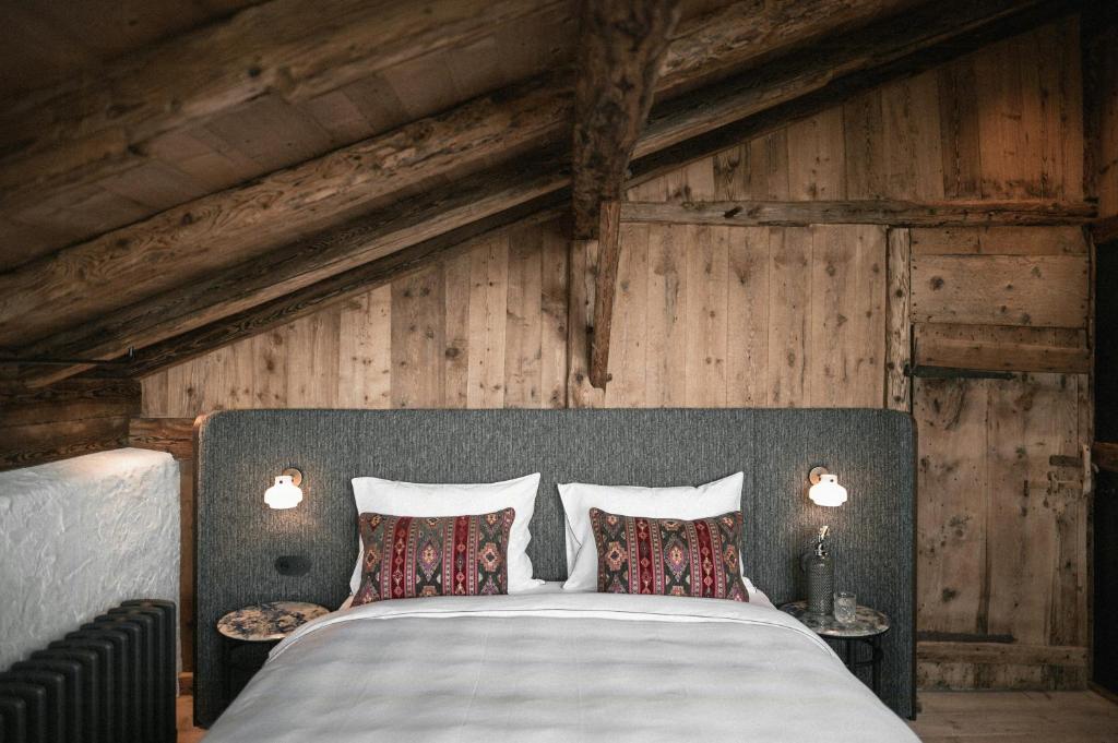 a bedroom with a large bed with two pillows at Historic Alpine Lodge In The Heart Of South Tyrol in Villandro