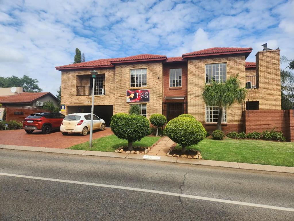 a brick house with a car parked in front of it at Hippo Zwartkop Suites in Centurion