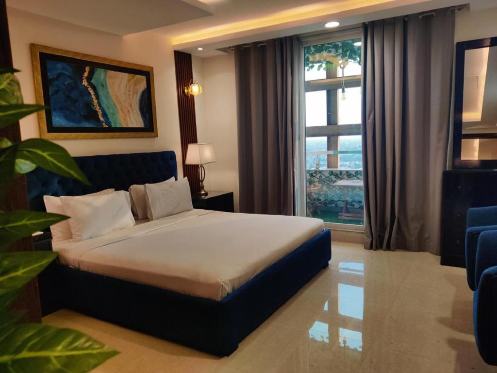 a hotel room with a bed and a large window at Modern 1 bedroom apartments in DHA in Lahore