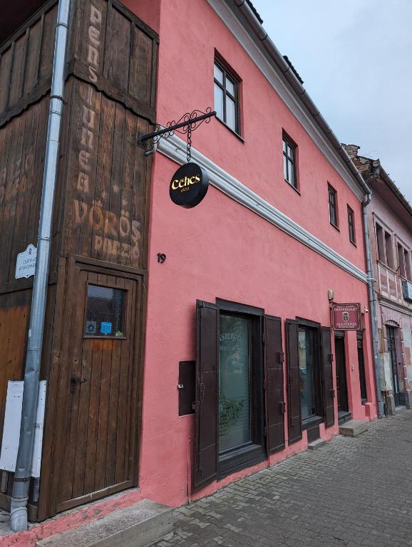 a red building on the side of a street at Céhes Guesthouse in Târgu Secuiesc