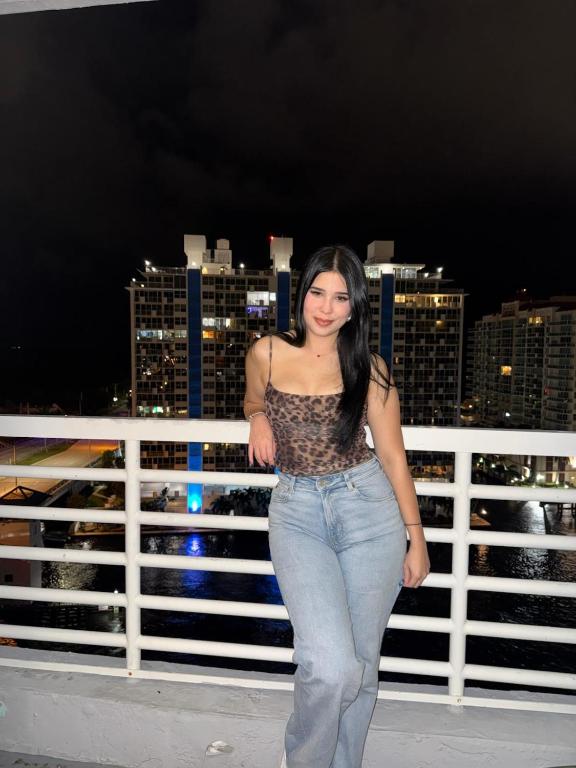a woman standing on a balcony with a city skyline at Luxury Waterfront Condo Hilton Hotel Amenities Beach Pool Jacuzzi Jetskis Gym in Fort Lauderdale