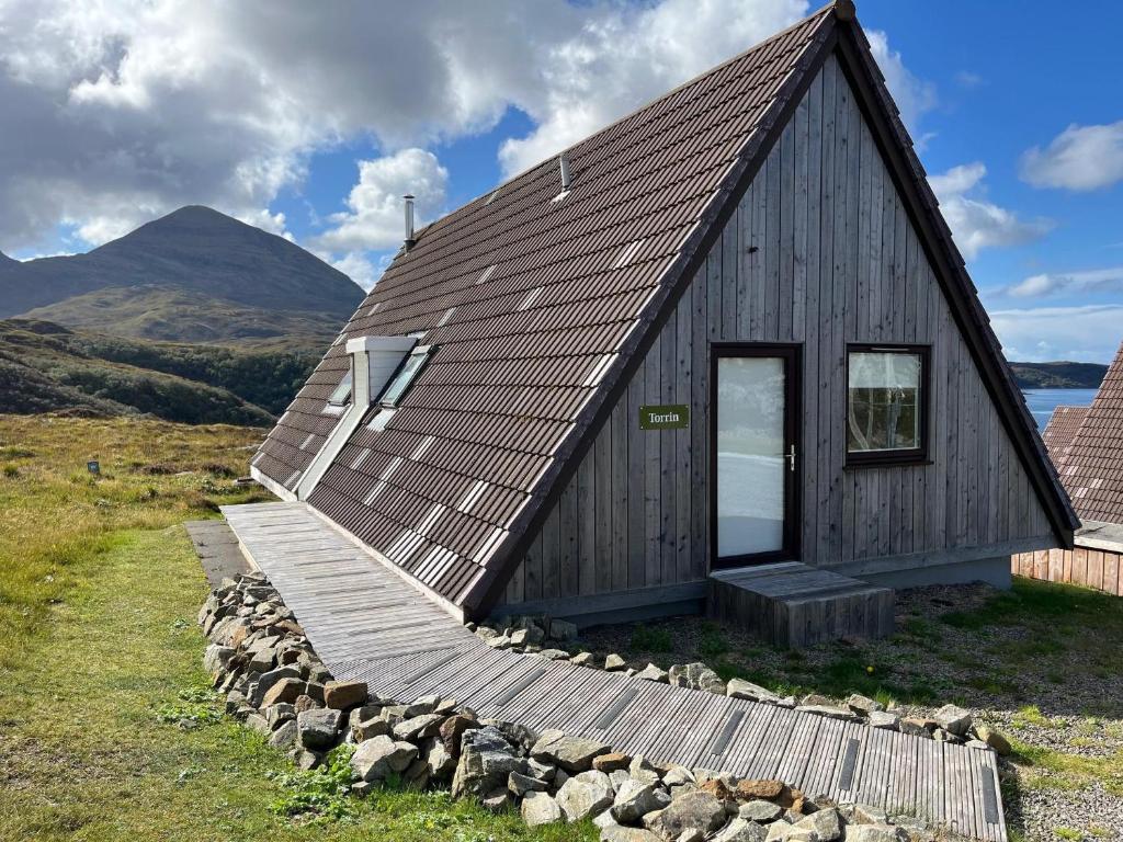 a small wooden house with a wooden walkway around it at Torrin - Uk50497 in Kylestrome